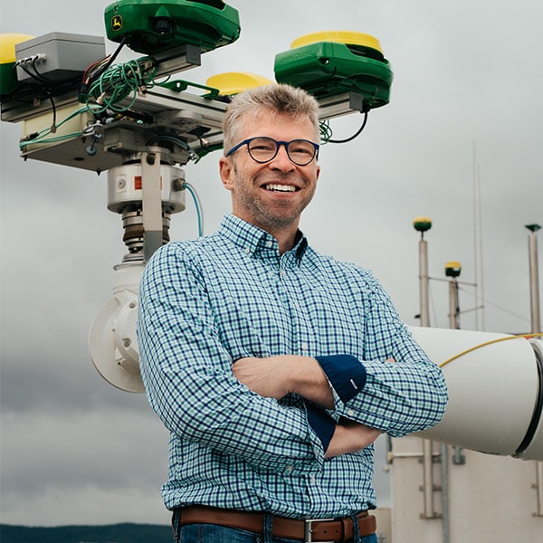 Kormann standing by a robotic arm.