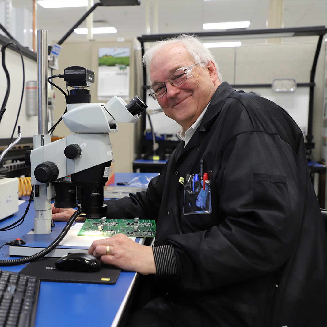 Dr. William F. Cooper sitting by a microscope