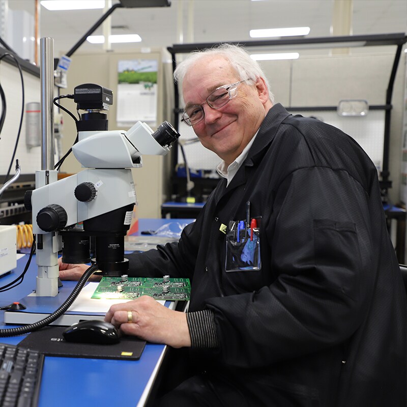 Dr. William F. Cooper sitting by a microscope